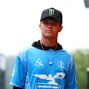 Lando marche sur le paddock avant le Grand Prix belge 2025 portant une chemise de style en jersey de son propre quadrant de marque. Swipe pour en voir plus