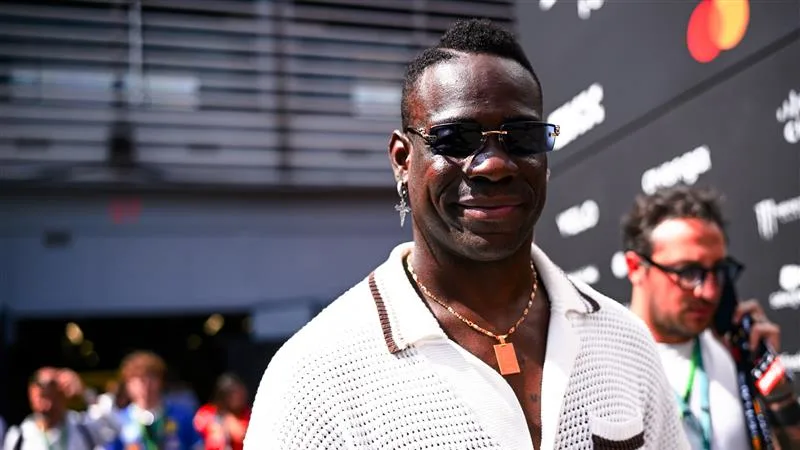 Mario Balotelli tourna la tête alors qu'il se dirigeait à travers le paddock - l'attaquant italien dessinant autant de caméras que les voitures. Swipe pour plus