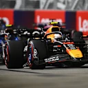 SINGAPORE, SINGAPORE - OCTOBER 05: Yuki Tsunoda of Japan driving the (22) Oracle Red Bull Racing RB21 leads Carlos Sainz of Spain driving the (55) Williams FW47 Mercedes on track during to the F1 Grand Prix of Singapore at Marina Bay Street Circuit on October 05, 2025 in Singapore, Singapore. (Photo by Clive Mason/Getty Images)
