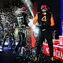 SINGAPORE, SINGAPORE - OCTOBER 05: Race winner George Russell of Great Britain and Mercedes AMG Petronas F1 Team Tengku Muhammad Taufik, CEO of Petronas and Third placed Lando Norris of Great Britain and McLaren celebrate on the podium with Champagne during the F1 Grand Prix of Singapore at Marina Bay Street Circuit on October 05, 2025 in Singapore, Singapore. (Photo by Mark Sutton - Formula 1/Formula 1 via Getty Images)